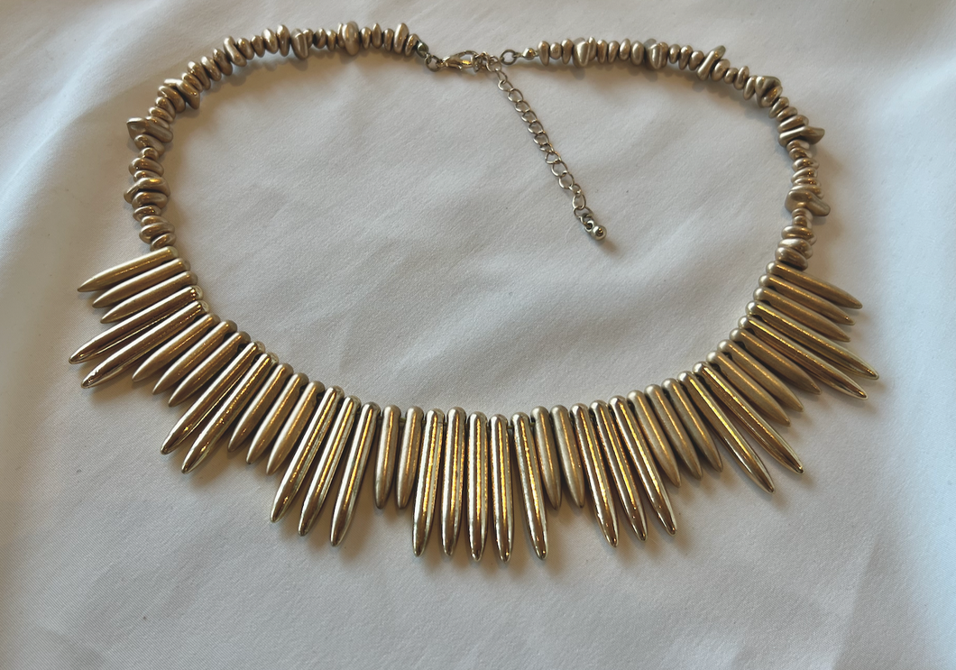 Golden nugget necklace w/striking points at bib RENTAL